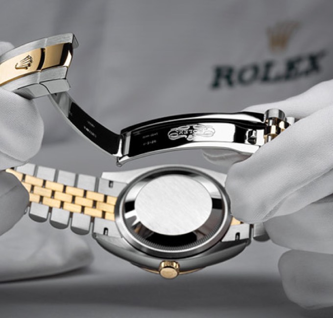Hands holding a Rolex watch for inspection